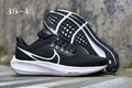 Nike Road Shoes for Running in Light Gray with Orange Swoosh - product image from the listing.