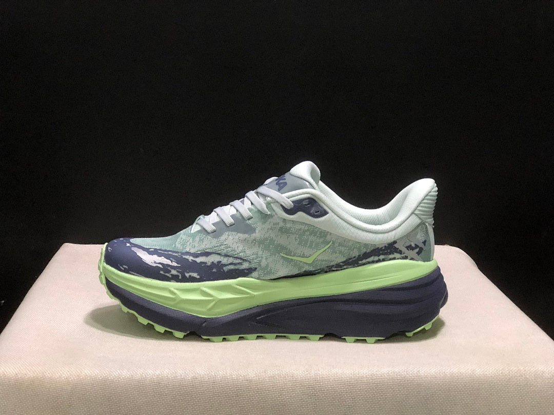 HOKA Stinson 7 Trail Running Shoes, in Green and Navy - product image from the listing.