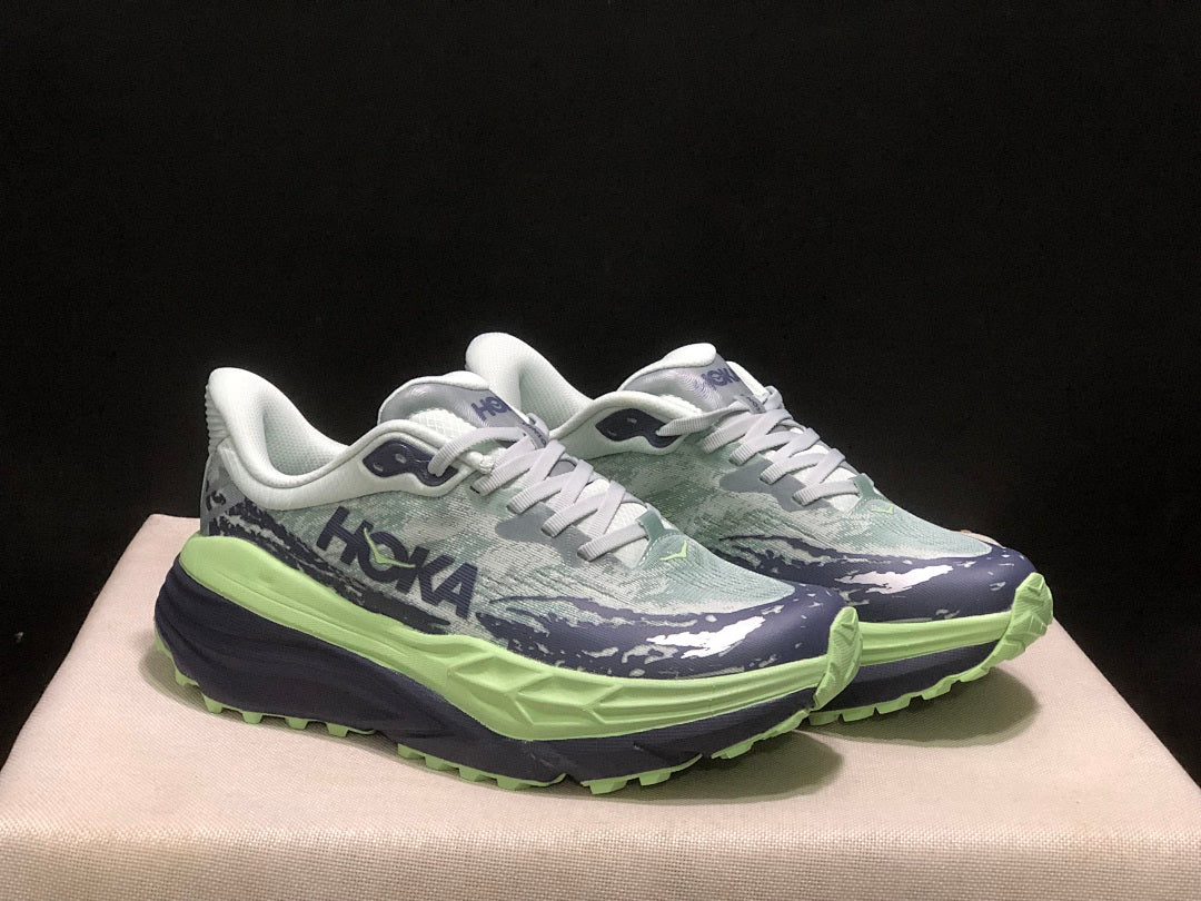 HOKA Stinson 7 Trail Running Shoes, in Green and Navy - product image from the listing.