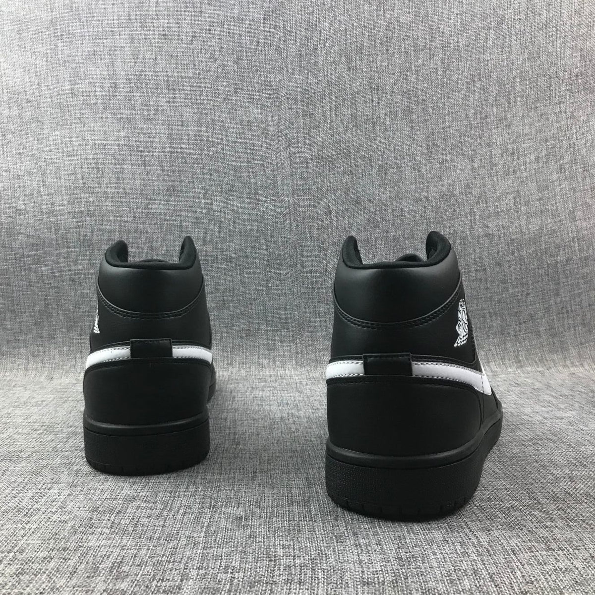 Air Jordan 1 Mid Sneakers in Black White 554724-049 - product image from the listing.