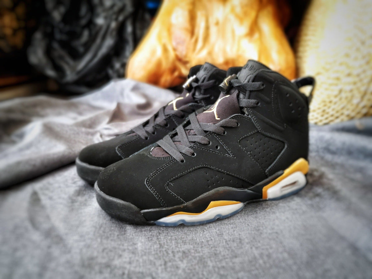 Air Jordan 6 High-Top Sneakers in Black and Gold - product image from the listing.